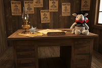 Plush toy resembling an armadillo with a cowboy hat and 'Texas' bandana on a wooden surface. Ranger Armadillo