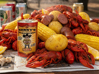 Platter of crawfish, corn, and potatoes with a can of Kenny's Cajun seasoning on a newspaper.